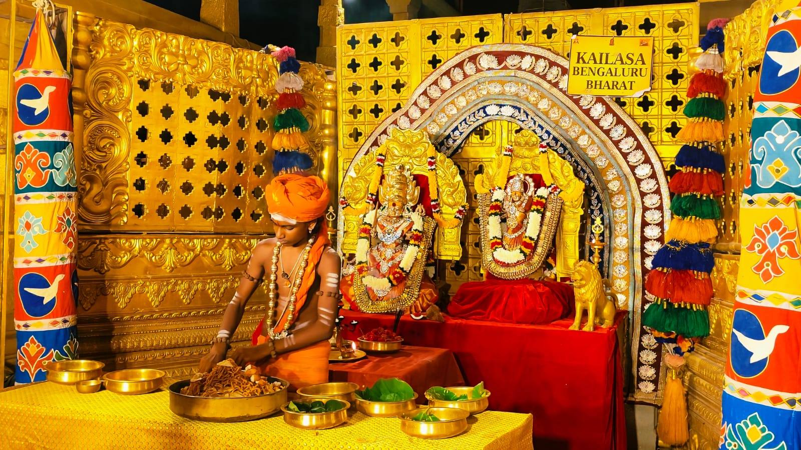 A bālasanyāsi arranges the sāttvic food offering before the deities