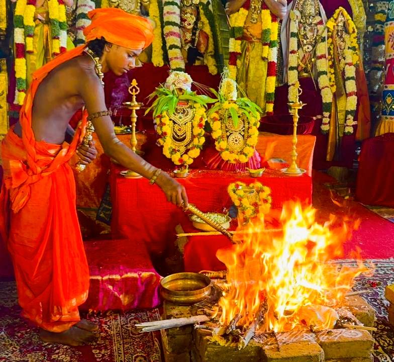 A bālasanyāsi performing the sacred fire homa before the deities